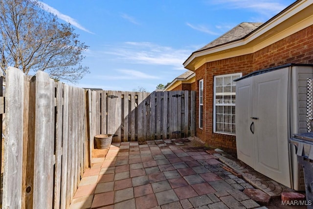 view of patio featuring a storage shed and fence