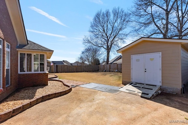 view of yard featuring a patio area, an outdoor structure, and a fenced backyard