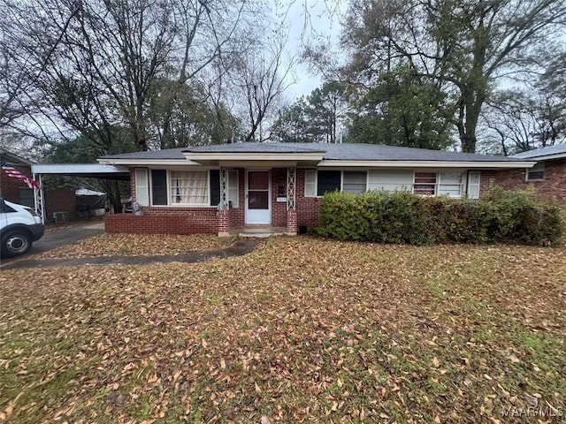 single story home featuring a carport, brick siding, and driveway