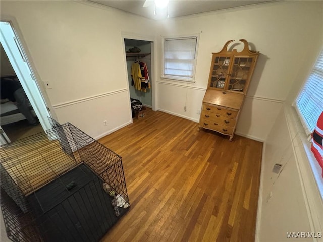 interior space with a ceiling fan, a closet, baseboards, and wood finished floors