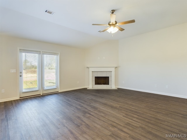 unfurnished living room with dark wood-style floors, a fireplace, visible vents, vaulted ceiling, and baseboards