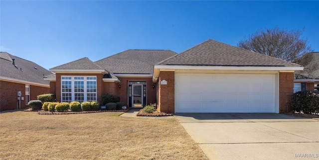 ranch-style home featuring an attached garage, a shingled roof, brick siding, driveway, and a front yard