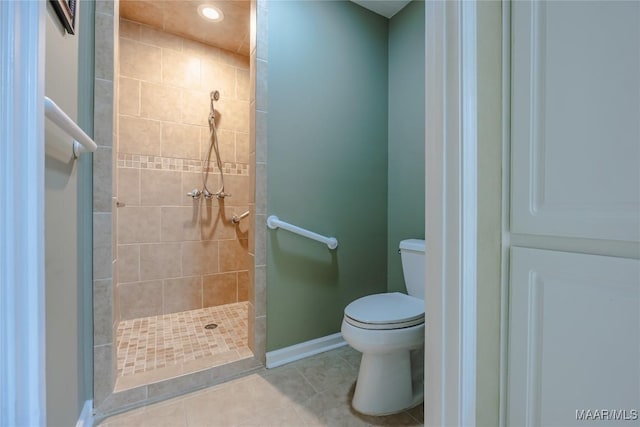 bathroom with baseboards, a stall shower, toilet, and tile patterned floors