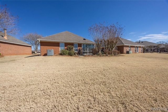 rear view of property featuring cooling unit and brick siding