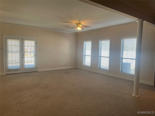 carpeted empty room with french doors, ornamental molding, a ceiling fan, and baseboards