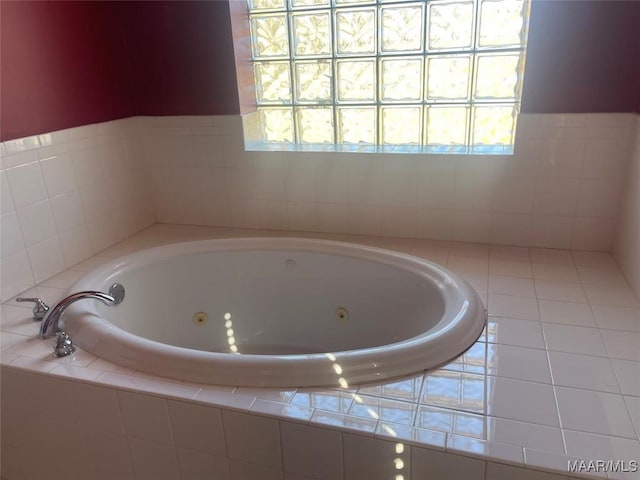 bathroom featuring a whirlpool tub and plenty of natural light