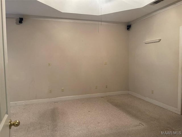 carpeted empty room featuring visible vents, ornamental molding, and baseboards