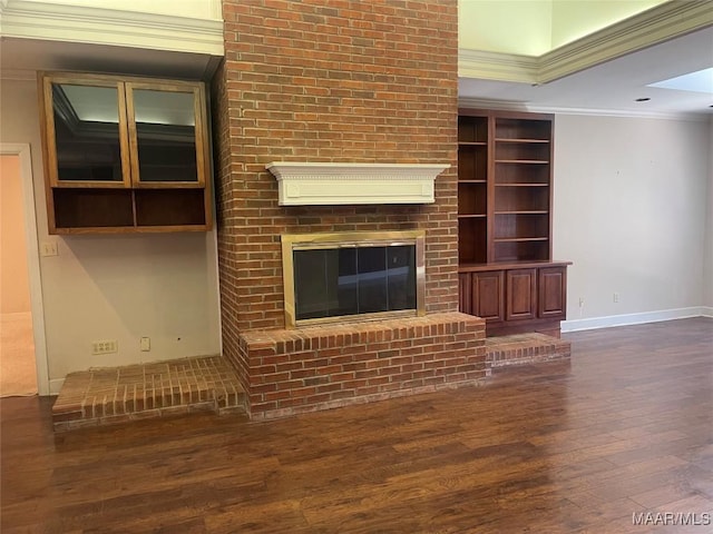 unfurnished living room featuring a brick fireplace, baseboards, crown molding, and dark wood-style flooring