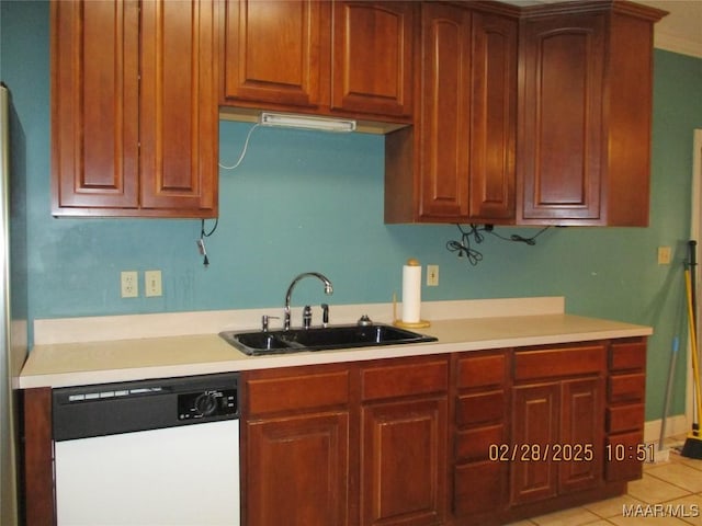 kitchen featuring dishwasher, light countertops, light tile patterned flooring, and a sink