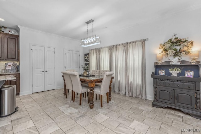 dining area featuring baseboards and ornamental molding