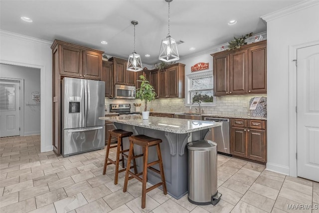 kitchen featuring a kitchen island, appliances with stainless steel finishes, light stone countertops, a kitchen bar, and pendant lighting