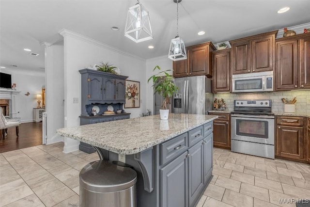 kitchen with decorative backsplash, a kitchen island, hanging light fixtures, stainless steel appliances, and crown molding