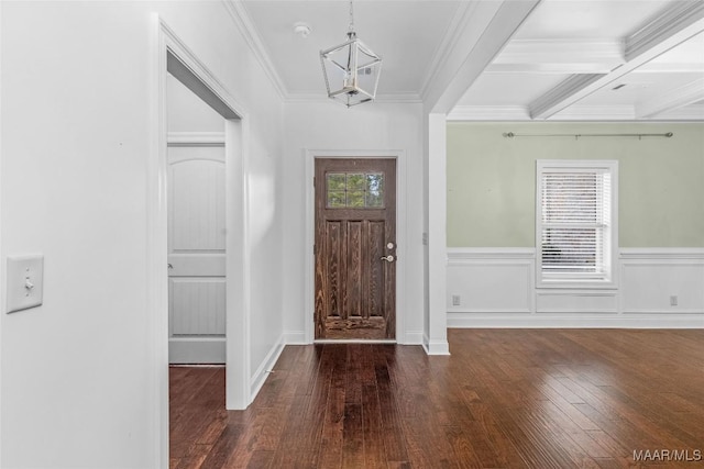 entrance foyer with coffered ceiling, a wainscoted wall, dark wood-type flooring, crown molding, and beam ceiling