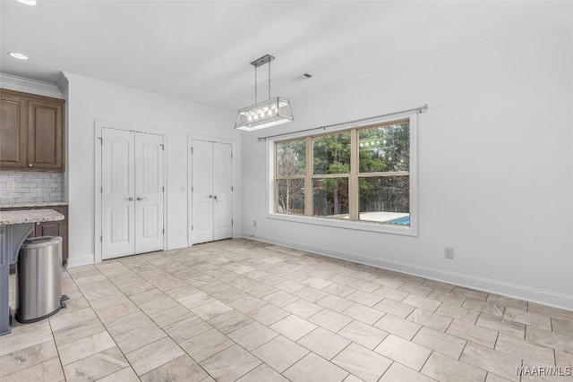 unfurnished dining area featuring visible vents, baseboards, and crown molding