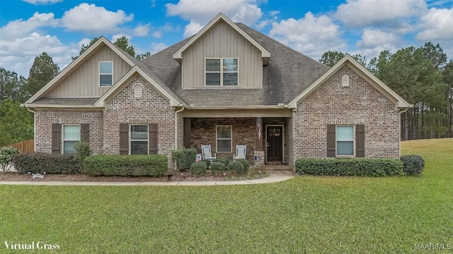 craftsman inspired home with brick siding, a shingled roof, and a front yard