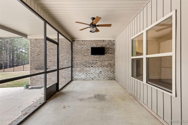 unfurnished sunroom with a ceiling fan