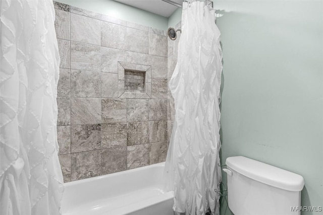 bathroom featuring toilet and shower / tub combo with curtain