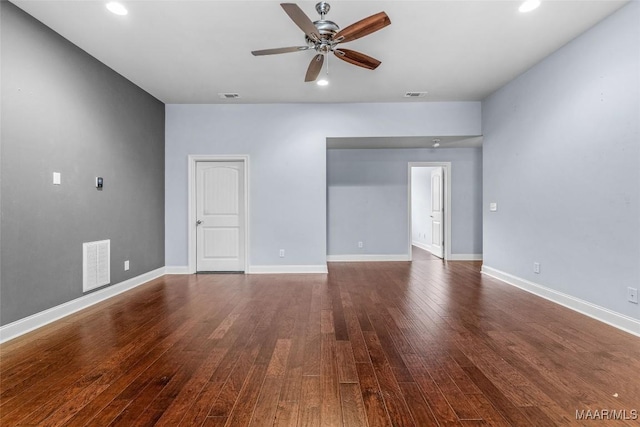 unfurnished room with visible vents, dark wood finished floors, and baseboards