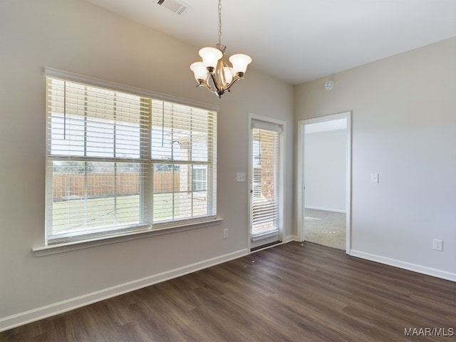 empty room featuring baseboards, visible vents, a chandelier, and dark wood-type flooring