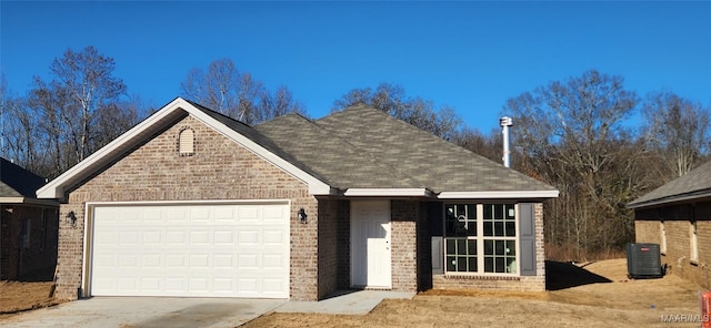 ranch-style home with brick siding, a shingled roof, concrete driveway, a garage, and cooling unit