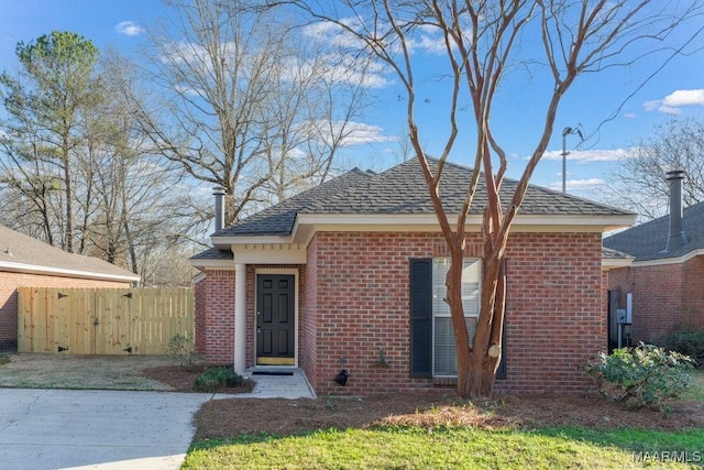 bungalow-style home featuring fence and brick siding