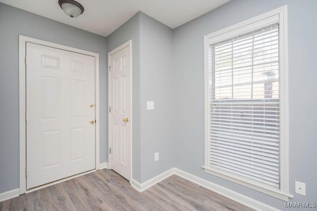 foyer entrance with light wood finished floors and baseboards