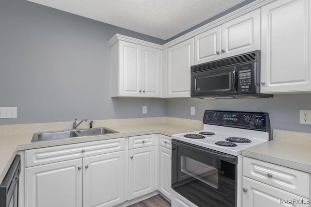 kitchen with black appliances, white cabinetry, light countertops, and a sink