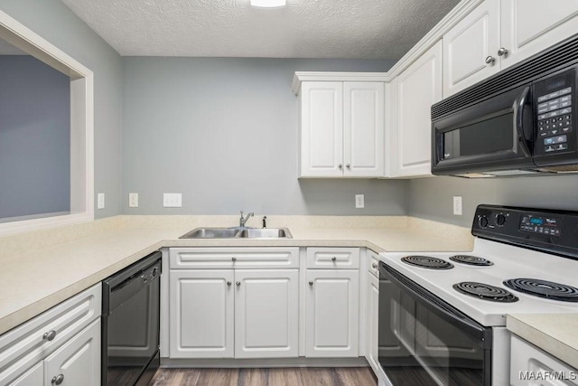 kitchen with a sink, black appliances, light countertops, and white cabinets