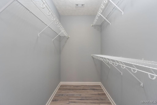 spacious closet with visible vents and wood finished floors