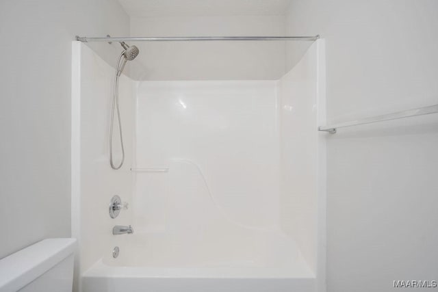 bathroom featuring shower / bathing tub combination and toilet