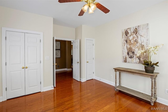 unfurnished bedroom with ceiling fan, baseboards, and wood finished floors