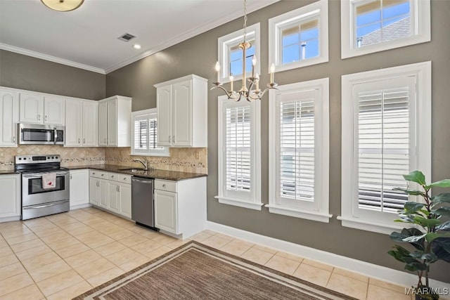 kitchen with visible vents, dark countertops, stainless steel appliances, white cabinetry, and a sink