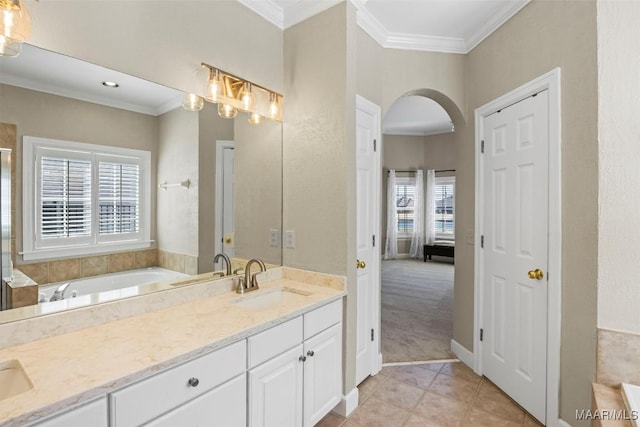 ensuite bathroom with double vanity, ornamental molding, ensuite bathroom, a sink, and a bath