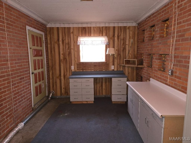 bathroom featuring ornamental molding and brick wall