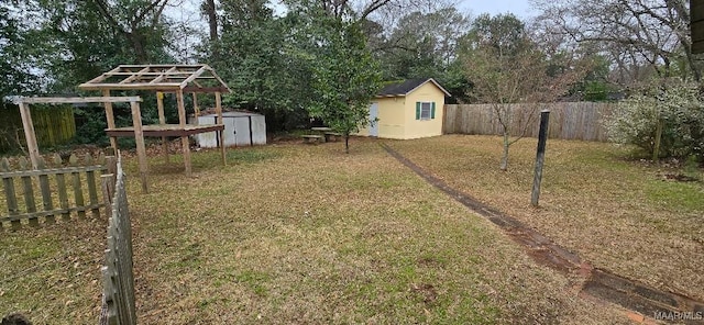 view of yard with a shed, a fenced backyard, and an outdoor structure