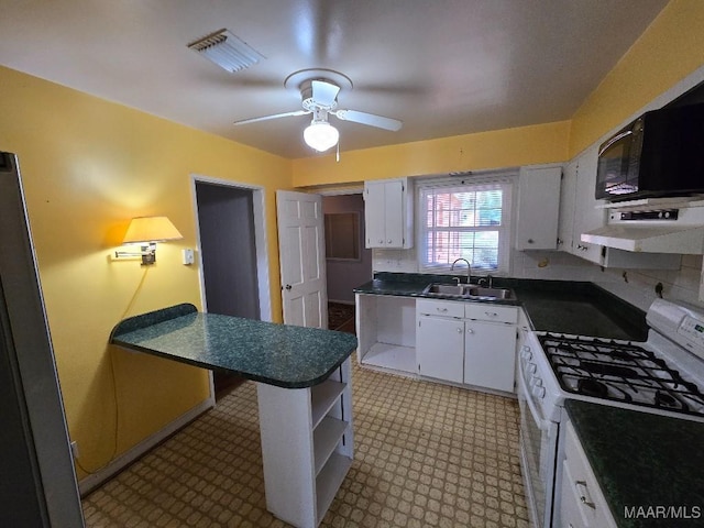 kitchen with white gas range, dark countertops, white cabinets, a sink, and extractor fan