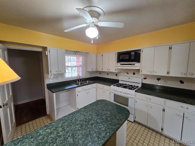 kitchen featuring white cabinets, dark countertops, gas range gas stove, black microwave, and a sink