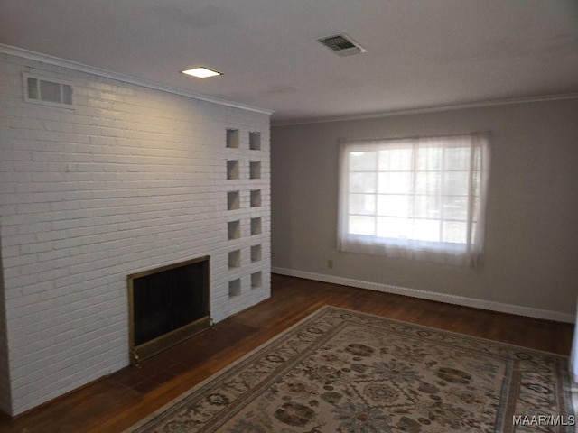 unfurnished living room with baseboards, visible vents, dark wood finished floors, ornamental molding, and a fireplace