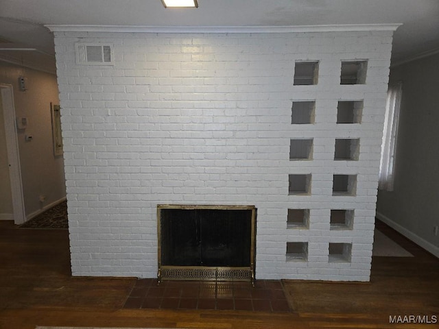 interior details with visible vents, ornamental molding, a large fireplace, wood finished floors, and baseboards