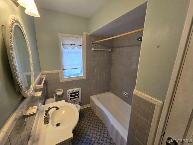 full bath with a wainscoted wall, heating unit, bathtub / shower combination, vanity, and tile walls