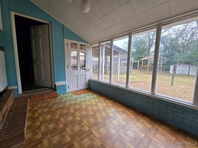 unfurnished sunroom featuring vaulted ceiling