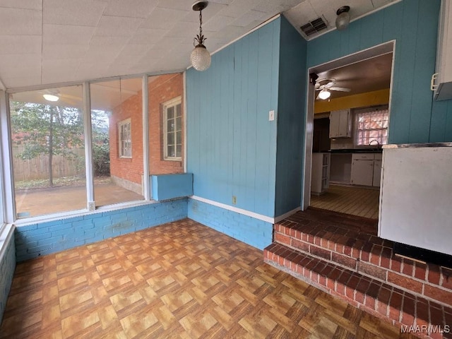 empty room with ceiling fan, a sink, and visible vents