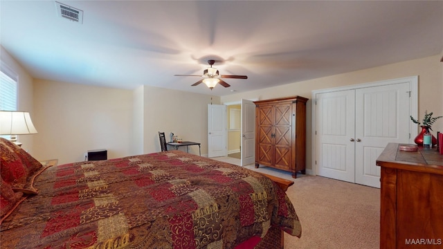 bedroom featuring a closet, light carpet, ceiling fan, and visible vents