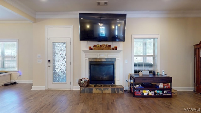 living room with visible vents, ornamental molding, wood finished floors, a tile fireplace, and baseboards