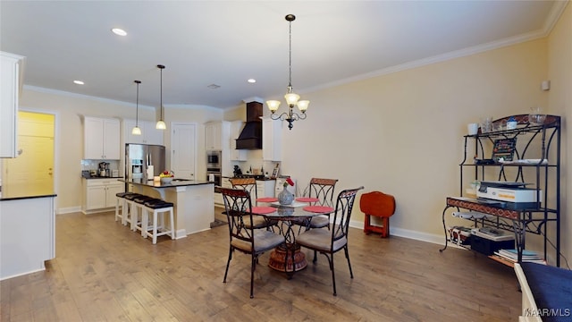 dining space featuring ornamental molding, light wood finished floors, and baseboards