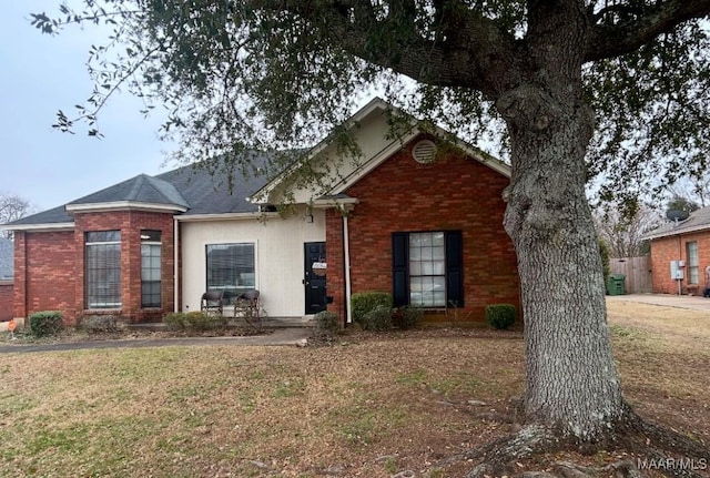 view of front of house featuring brick siding and a front lawn