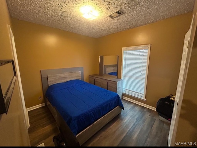 bedroom featuring lofted ceiling, visible vents, a textured ceiling, and wood finished floors