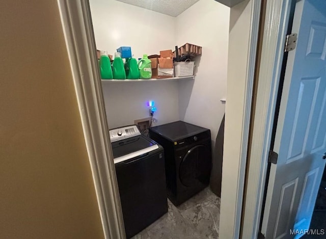 laundry room featuring laundry area, washer and clothes dryer, and a textured ceiling