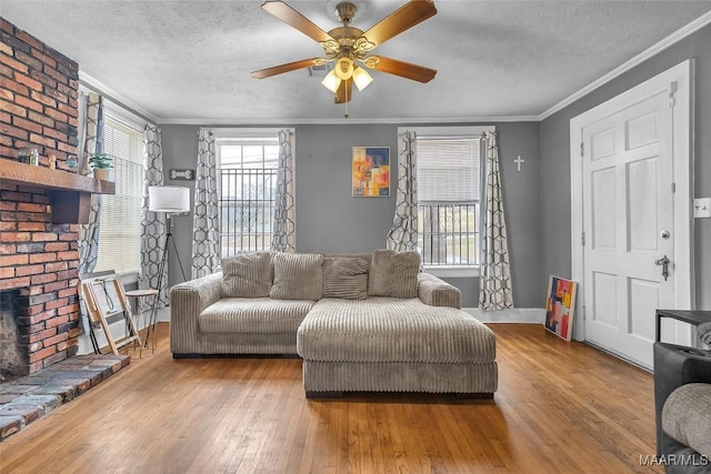 living room with a wealth of natural light, wood-type flooring, crown molding, and a textured ceiling