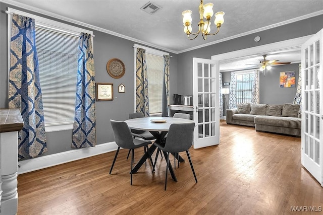 dining space with ornamental molding, french doors, wood finished floors, and visible vents